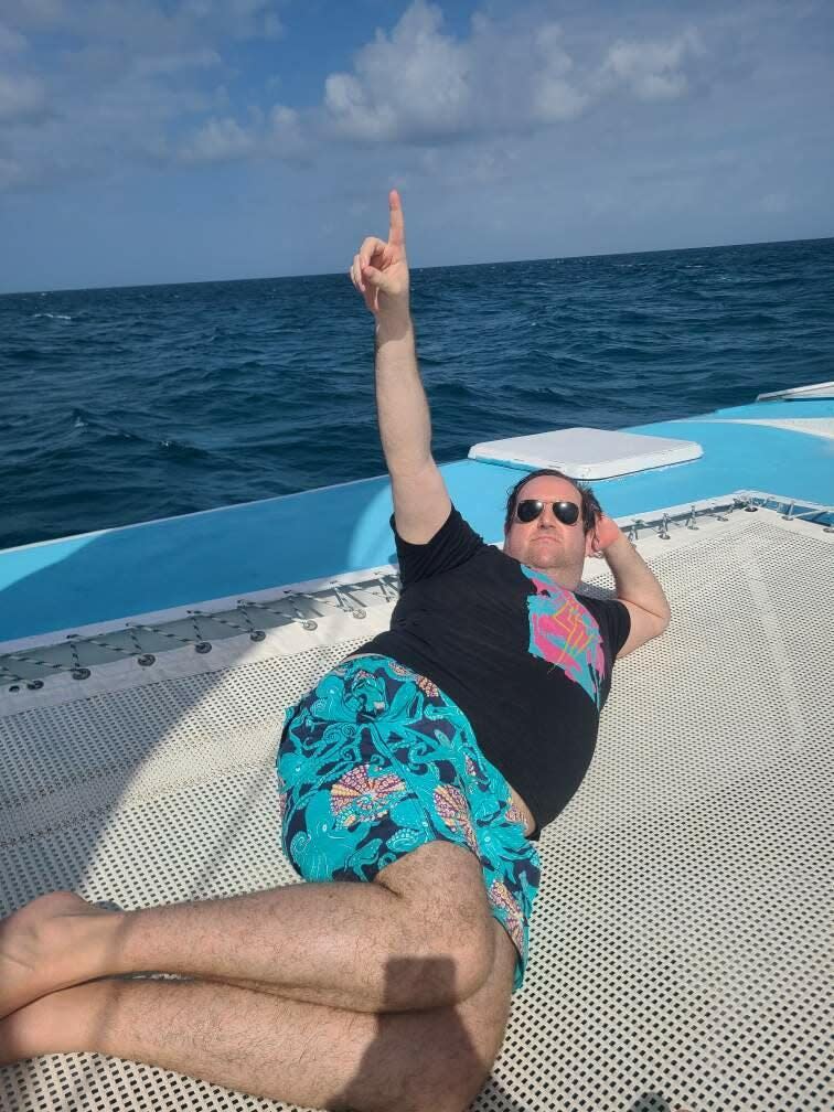 man laying on catamaran in the ocean