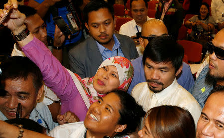 Supporters take a selfie with Philippine boxing star and Senator Manny Pacquiao after he was declared by elections officials as one of the 12 new members of the upper house of Congress in Manila, Philippines May 19, 2016. REUTERS/Erik De Castro