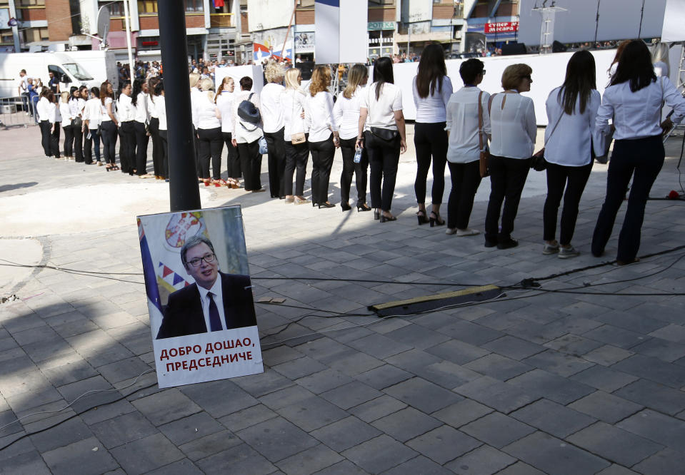 Kosovo Serbs wait for a rally of Serbian President Aleksandar Vucic in the northern, Serb-dominated part of Mitrovica, Kosovo, Sunday, Sept. 9, 2018. A poster, left, showing Serbian President Aleksandar Vucic reads '"Welcome, President". NATO-led peacekeepers in Kosovo say the safety of Serbia President Aleksandar Vucic during a visit to Kosovo isn't threatened despite roadblocks that prevented his visit to a central Serb-populated village. (AP Photo/Darko Vojinovic)