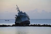 A ship rests on rocks after it ran aground during storms brought on by Super Typhoon Maysak near the coastal village of Neauo, in the Micronesian state of Chuuk, on March 29, 2015