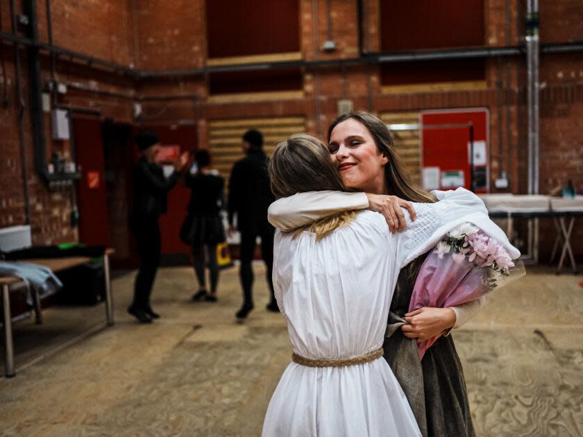 Two women hug in costume.