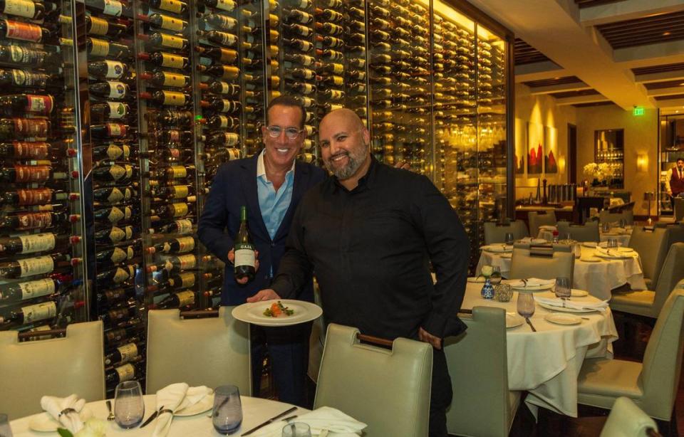 Owner Thomas P. Angelo and Chef Danny Ganem next to a wall of wine at Fiola restaurant in Coral Gables.