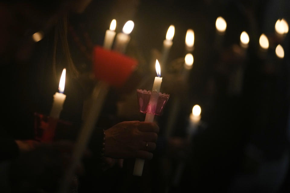 Worshippers hold candles as they attend Mass on the eve of Christ's resurrection at the Church of St. George on the island of Gokceada, (Greek name: Imvros), Turkey, Sunday, April 16, 2023. (AP Photo/Khalil Hamra)