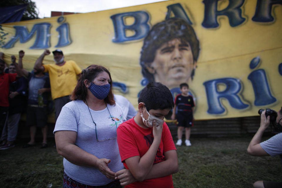 Neighbors gather in front of the house where Diego Maradona was born in the Villa Fiorito neighborhood of Buenos Aires, Argentina, Wednesday, Nov. 25, 2020. The Argentine soccer great who was among the best players ever and who led his country to the 1986 World Cup title before later struggling with cocaine use and obesity, died from a heart attack on Wednesday at his home in Buenos Aires. He was 60.(AP Photo/Natacha Pisarenko)