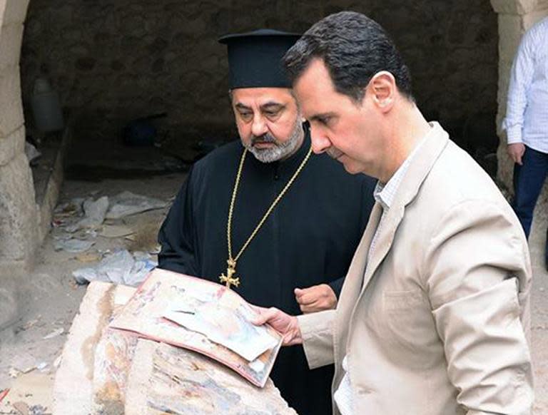 Picture uploaded on the official Facebook page of the Syrian Presidency on April 20, 2014, shows Syria's President Bashar al-Assad looking at icons at a monastery in the ancient Christian town of Maalula, recently recaptured from rebels