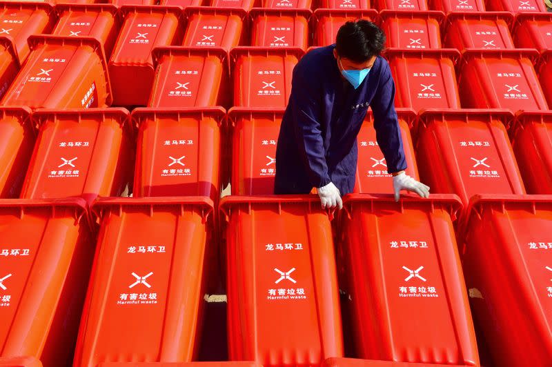 Worker wearing a face mask is seen among dustbins for harmful waste at a company producing sanitation supplies in Ganzhou