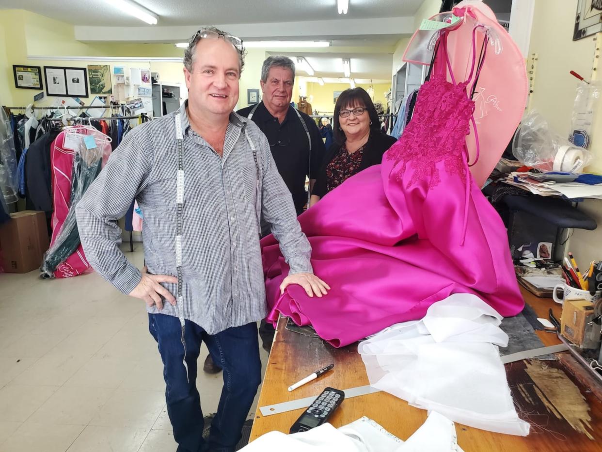 From left, Mike, Tony Jr., and Theresa at Tony's Tailor Shop on Freshwater Road. Mike is working on a prom gown. 'I was gonna tell you a tailoring joke but I ran out of material,' he says.  (Susan Flanagan - image credit)
