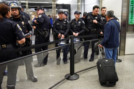 Police redirect travelers after the security check point was closed due to protests in Terminal 4 at San Francisco International Airport in San Francisco, California, U.S., January 28, 2017. REUTERS/Kate Munsch