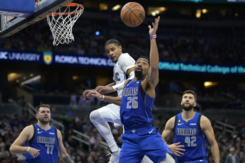 Dallas Mavericks guard Spencer Dinwiddie (26) reaches for a rebound next to Orlando Magic forward Chuma Okeke as Magic guard Luka Doncic (77) and forward Maxi Kleber (42) watch during the second half of an NBA basketball game Wednesday, Nov. 9, 2022, in Orlando, Fla. (AP Photo/Phelan M. Ebenhack)