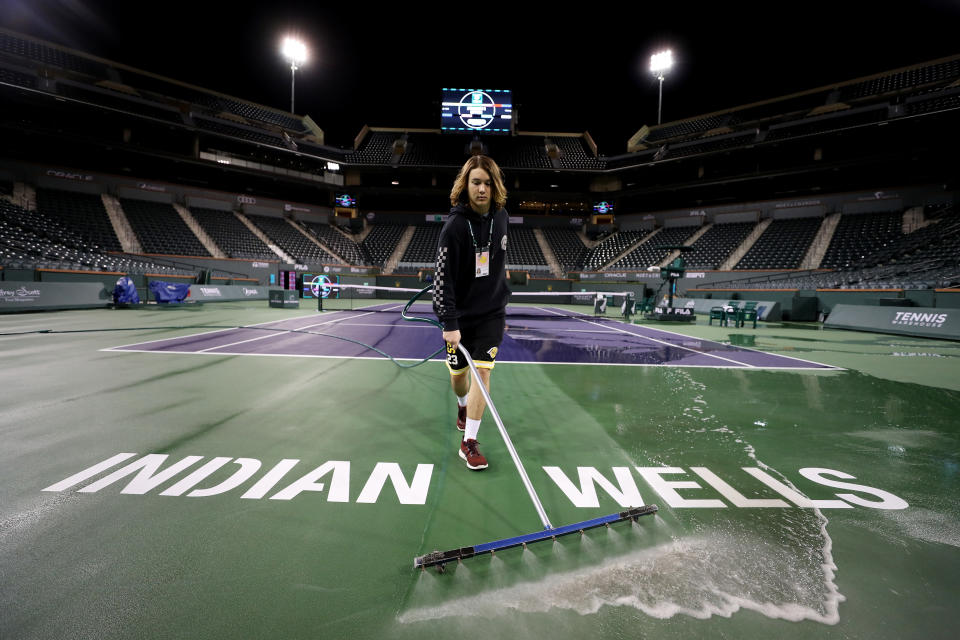 Courtmaster Jeffrey Brooker sprays and cleans the centre court at the Indian Wells Tennis Garden.