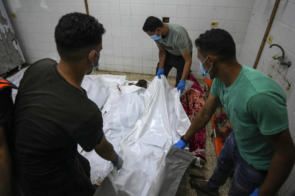 Palestinians carry the bodies of their relatives killed in the Israeli bombardment of Al Zawayda in central Gaza Strip, at the morgue of Al Aqsa hospital in Deir al Balah, Gaza Strip, early Wednesday, May 22, 2024. (AP Photo/Abdel Kareem Hana)