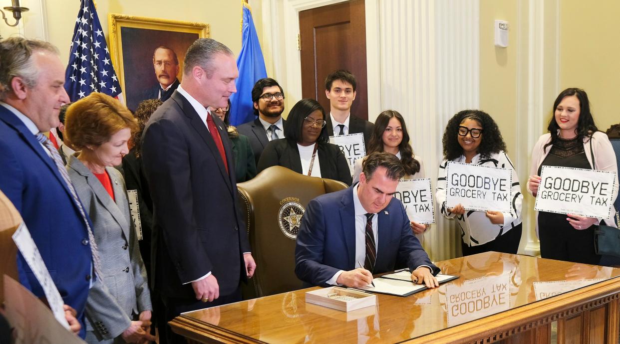 Gov. Kevin Stitt signs the grocery tax cut bill Feb. 27 as legislative Leaders and others look on at the signing ceremony in the Blue Room at the Oklahoma Capitol.