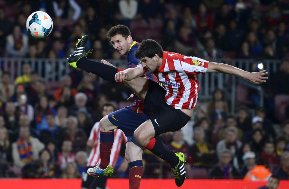 FC Barcelona's Lionel Messi, from Argentina, left, duels for the ball against Athletic Bilbao's Mikel San Jose during a Spanish La Liga soccer match at the Camp Nou stadium in Barcelona, Spain, Sunday April 20, 2014. (AP Photo/Manu Fernandez)