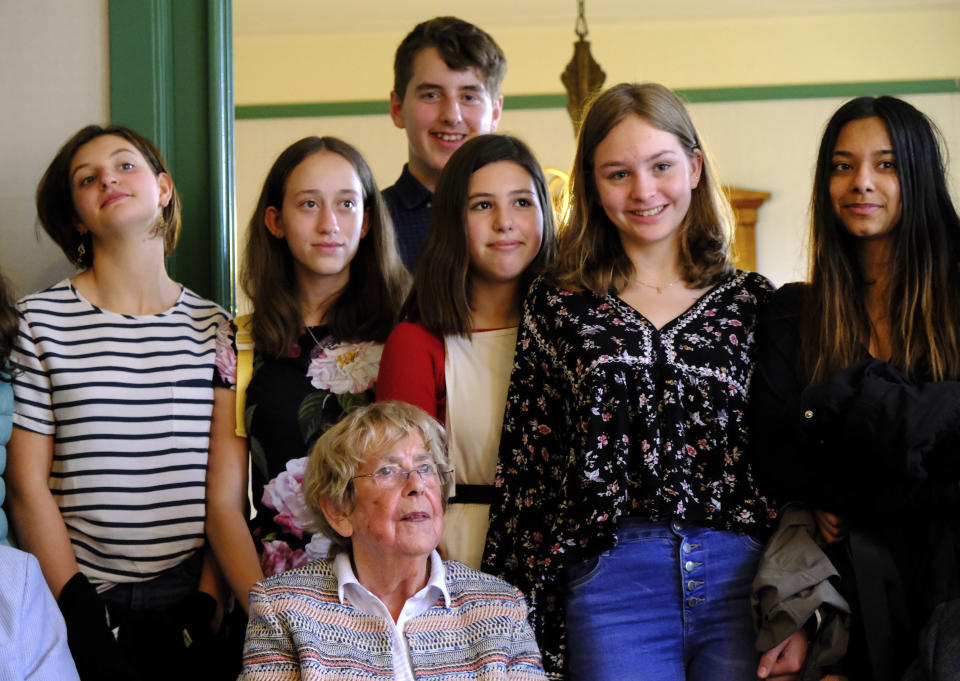 Jacqueline van Maarsen, center, poses for a photo with students from the International School of Amsterdam during an event to mark what would have been Anne Frank's 90th birthday, in Amsterdam on Wednesday, June 12, 2019. On the day Anne Frank would have turned 90, the museum dedicated to keeping alive her story has brought together schoolchildren and two of the Jewish diarist's friends at the apartment where she lived with her family before going into hiding from Nazis who occupied the Netherlands during World War II. (AP Photo/Michael C. Corder)