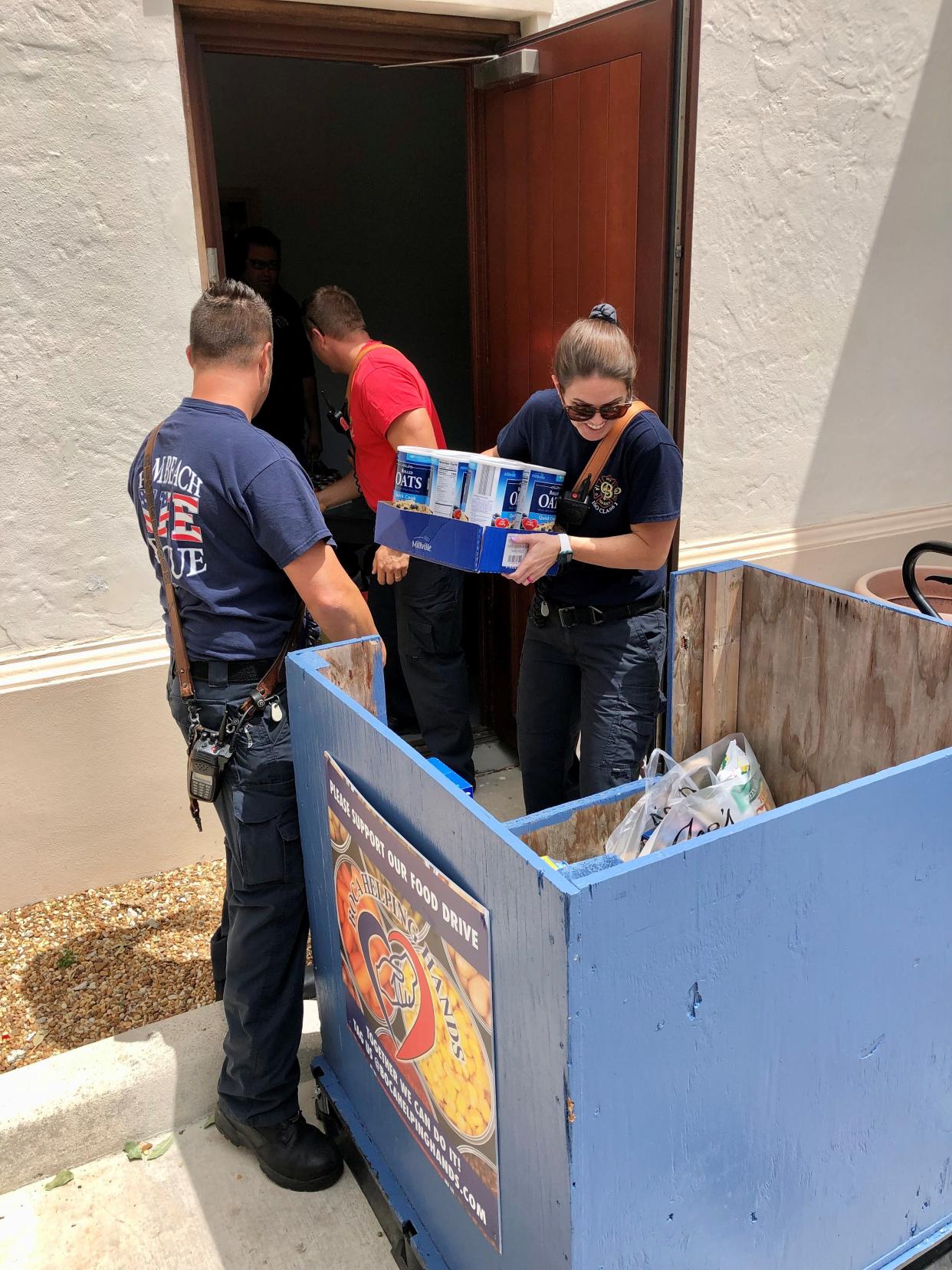 Palm Beach Fire Rescue Lt. Anthony Curtis, firefighter Robert Richardson and firefighter Kelsey Mazzola load donations recently from the Empty Your Pantry Food Drive.