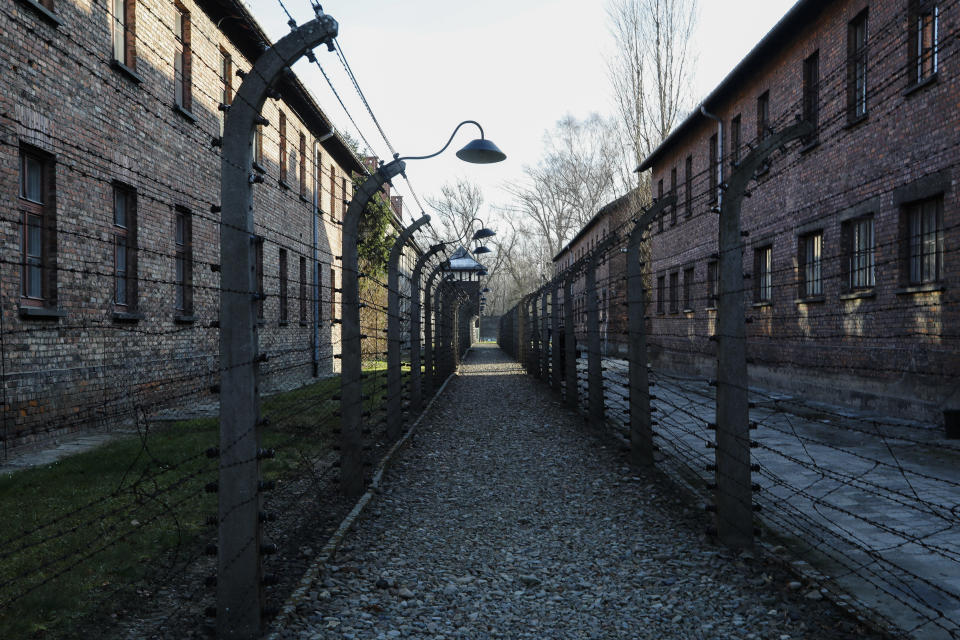 A pathway leading to an observation and security tower between what were electric barbed wire fences inside the former Nazi death camp of Auschwitz I in Oswiecim, Poland, Sunday, Dec. 8, 2019. The commemorations for the victims of the Holocaust at the International Holocaust Remembrance Day, marking the liberation of Auschwitz-Birkenau on Jan. 27, 1945, will be mostly online in 2021 due to the coronavirus pandemic. (AP Photo/Markus Schreiber)