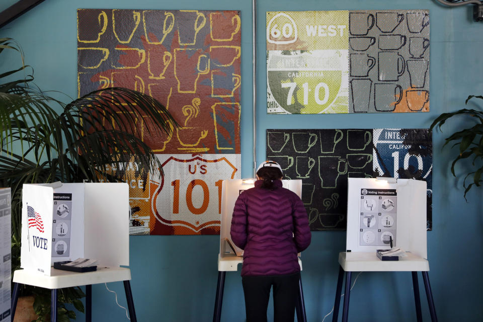 FILE - In this March 7, 2017 file photo, a woman votes at a polling station inside a coffee shop in Los Angeles. With the 2020 elections approaching, the latest California voter registration figures tell a familiar story: Democrats are expanding their ranks, Republicans are struggling and the fastest-growing group remains those voters aligned with no party at all - independents. The figures released Wednesday, Nov. 6, 2019 by Secretary of State Alex Padilla also show that more than 80 percent of eligible residents are registered to vote, the highest percentage since 1952. (AP Photo/Jae C. Hong, File)