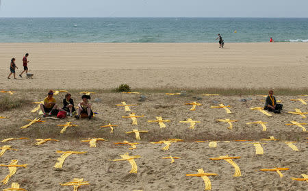 Catalan separatist supporters place yellow crosses during a protest to demand the release of jailed Catalonian politicians, at Mataro's beach, north of Barcelona, Spain May 27, 2018. REUTERS/Albert Gea