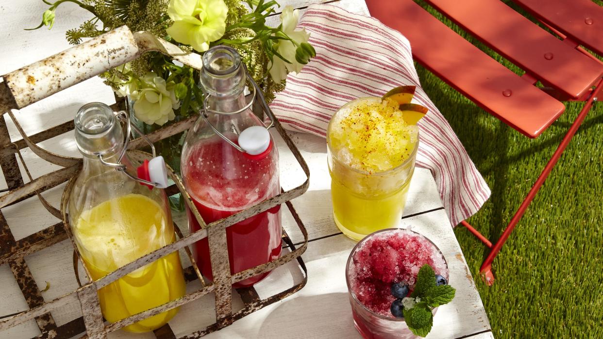 three different snow cone cocktails on a table outside