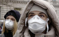 Women wearing face masks take part in a protest against air pollution, in Sarajevo, Bosnia, Monday, Jan. 20, 2020. Dozens of people, some wearing face masks, gathered for a protest because of dangerously high levels of air pollution in the past weeks in the Bosnian capital after measurements in the past weeks have shown that levels of damaging airborne particles have exceeded European Union's safety norms by several times.(AP Photo/Eldar Emric)