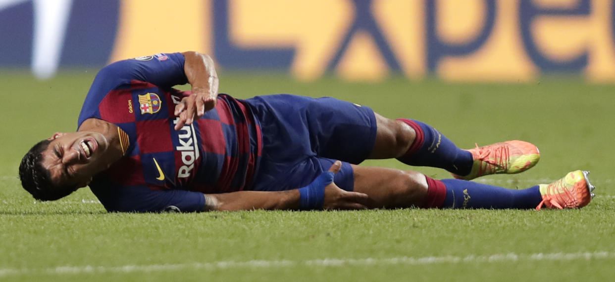 Barcelona's Luis Suarez grimaces after being fouled during the Champions League quarterfinal match between FC Barcelona and Bayern Munich at the Luz stadium in Lisbon, Portugal, Friday, Aug. 14, 2020. (AP Photo/Manu Fernandez/Pool)