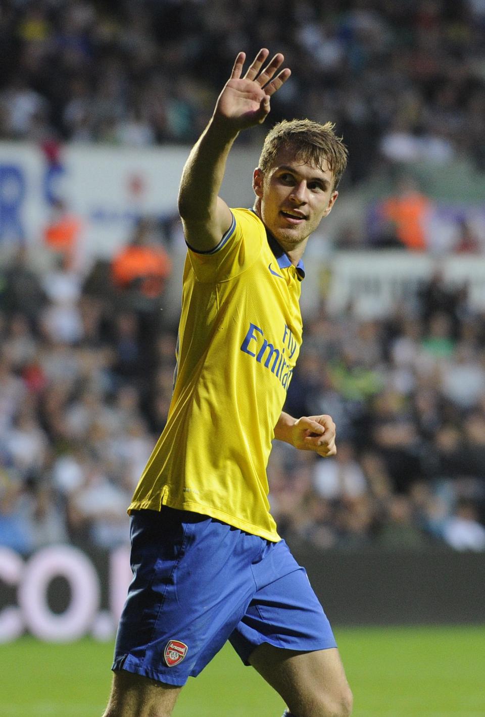 Arsenal's Aaron Ramsey waves to his team's supporters after scoring a goal during their English Premier League soccer match at the Liberty Stadium, Swansea, Wales September 28, 2013. REUTERS/Rebecca Naden (BRITAIN - Tags: SPORT SOCCER) NO USE WITH UNAUTHORIZED AUDIO, VIDEO, DATA, FIXTURE LISTS, CLUB/LEAGUE LOGOS OR "LIVE" SERVICES. ONLINE IN-MATCH USE LIMITED TO 45 IMAGES, NO VIDEO EMULATION. NO USE IN BETTING, GAMES OR SINGLE CLUB/LEAGUE/PLAYER PUBLICATIONS. FOR EDITORIAL USE ONLY. NOT FOR SALE FOR MARKETING OR ADVERTISING CAMPAIGNS