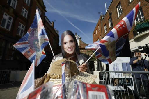 A woman selling flags featuring Britain's Prince Harry and US actress Meghan Markle near Windsor Castle in Windsor on May 18, 2018, the day before the Royal wedding