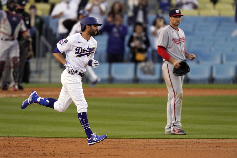 Los Angeles Dodgers' Chris Taylor, left, runs by Washington Nationals first baseman Ryan Zimmerman after hitting a three-run home run during the second inning of a baseball game Saturday, April 10, 2021, in Los Angeles. (AP Photo/Mark J. Terrill)