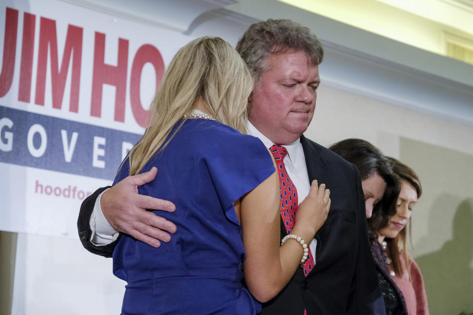 Democratic candidate and state Attorney General Jim Hood comforts his daughter Annabelle as wife Debbie and daughter Rebecca, far right, pray after conceding to Gov.-elect Tate Reeves, Tuesday, Nov. 5, 2019, at Hilton Gardens Inn in Jackson, Miss. (AP Photo/Charles A. Smith)