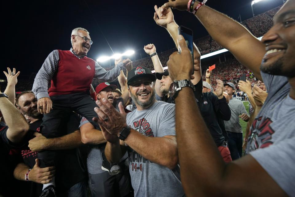 Members of the 2002 Ohio State national championship team hoist coach Jim Tressel as the team is recognized after the first quarter of a game between the Buckeyes and Notre Dame at Ohio Stadium.