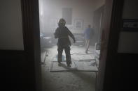 A firefighter walks inside the Congress building after protesters set a part of the building on fire, in Guatemala City, Saturday, Nov. 21, 2020. Hundreds of protesters were protesting in various parts of the country Saturday against Guatemalan President Alejandro Giammattei and members of Congress for the approval of the 2021 budget that reduced funds for education, health and the fight for human rights. (AP Photo/Moises Castillo)