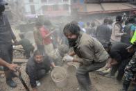 People clear rubble in Kathmandu's Durbar Square, a UNESCO World Heritage Site that was severely damaged by an earthquake on April 25, 2015