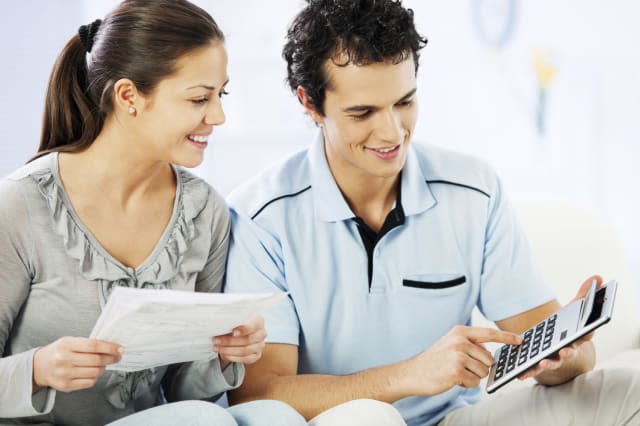 Young cheerful couple doing their taxes.