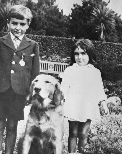 <p>Elizabeth was born in Hampstead Garden, a suburb of London, England. Here, a five-year-old Elizabeth and her brother, Howard, pose with their family's golden retriever. </p>