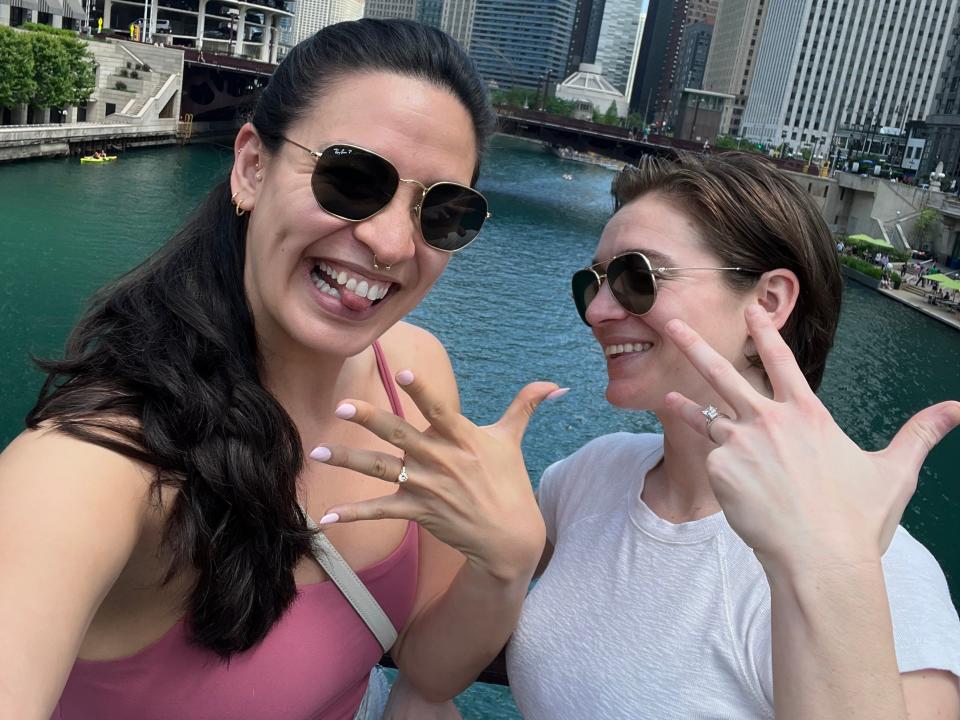 Kayla McCarty and Kat Messinger posing with their engagement rings in Chicago.