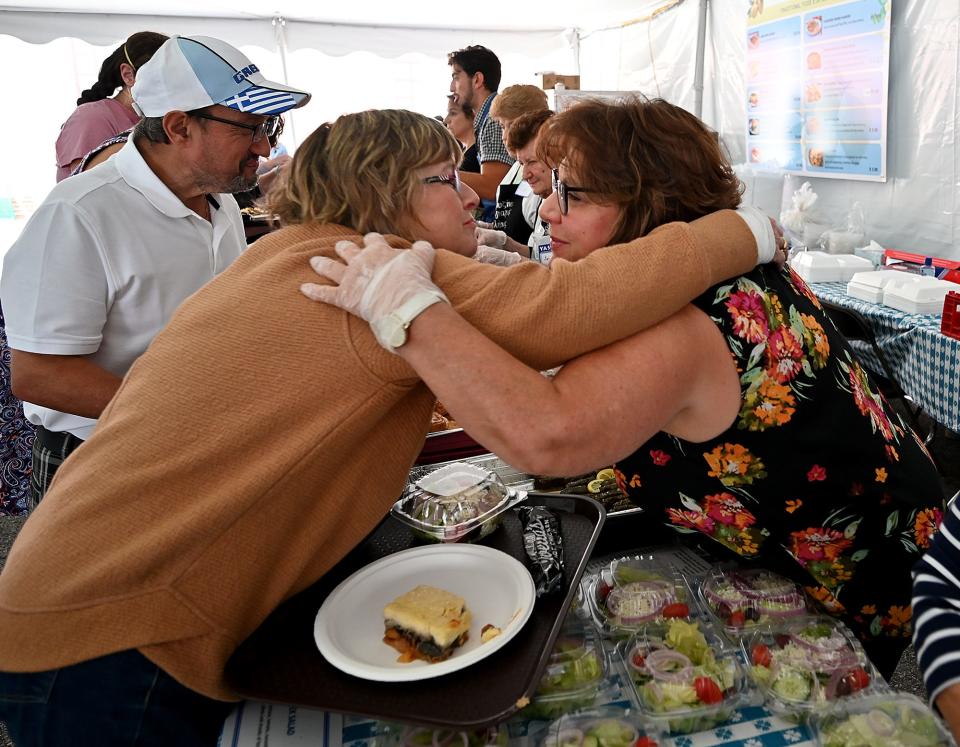 Sharon Konstanpinidis, left, leans in to hug Penny Stamos, who was working the food line Saturday during the St. Spyridon Grecian Festival at St. Spyridon Greek Orthodox Cathedral.