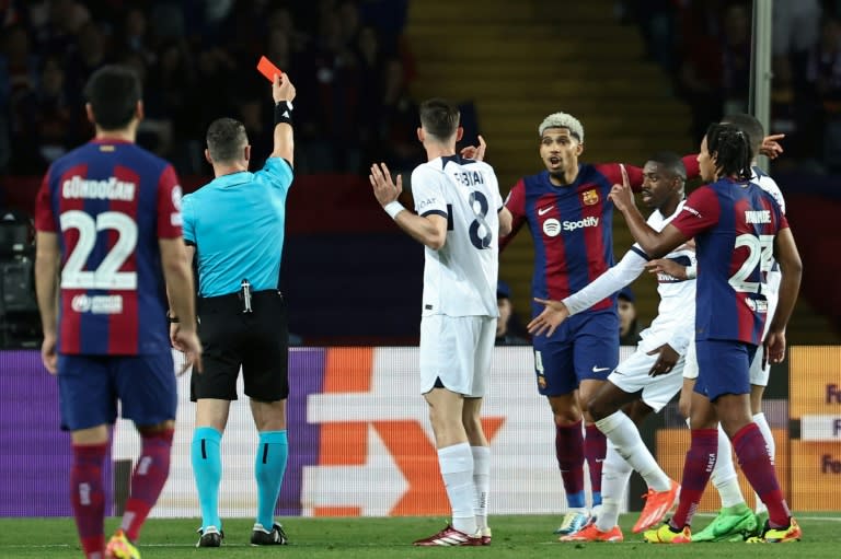 El árbitro Istvan Kovacs muestra la tarjeta roja al central uruguayo del Barcelona Ronald Araujo en el partido de vuelta de cuartos de final de la Champions contra el PSG el 16 de abril de 2024 en el estadio Olímpico Lluis Companys de Barcelona. (FRANCK FIFE)