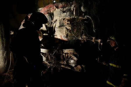 Firefighters walk past the damaged engine of a train that derailed and crashed in the town of Adendro in northern Greece, May 13, 2017. REUTERS/Alexandros Avramidis