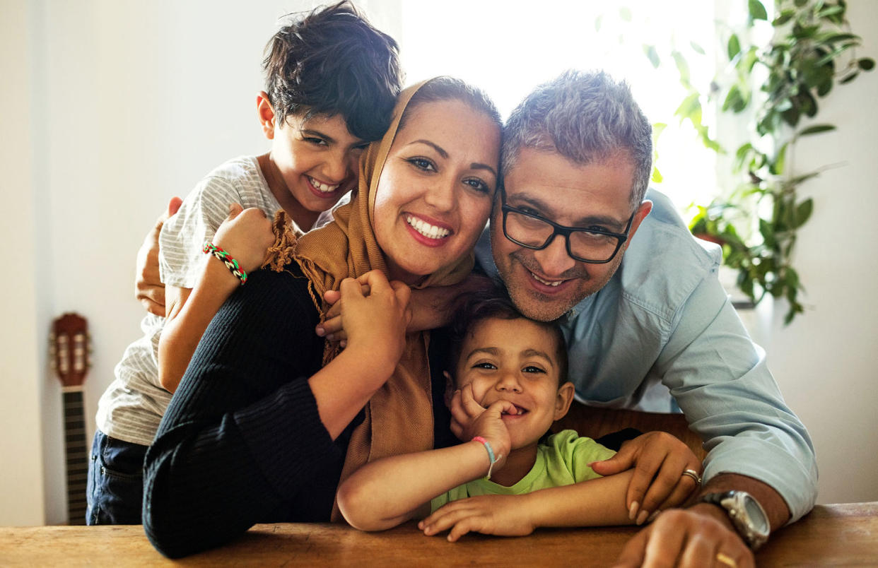 Portrait of happy family sitting at table (Getty Images)