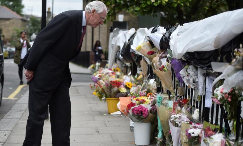 Martin Moore-Bick examines floral tributes after the Grenfell tower fire