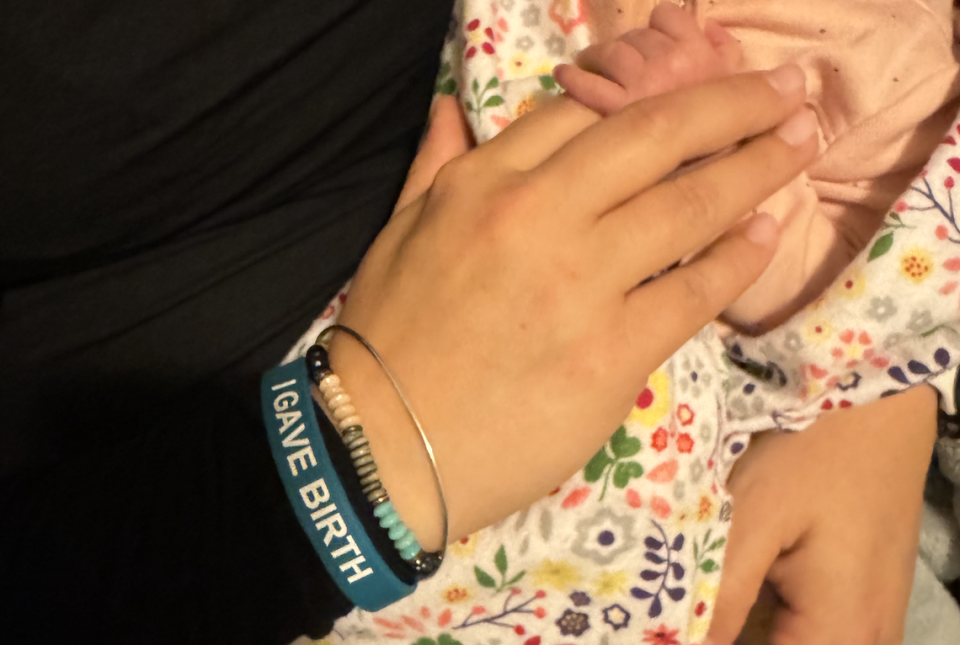 Christina Buchanan wears an “I Gave Birth” bracelet as part of a new UNC Rex initiative while holding her newborn, Caelah. Jesse Buchanan