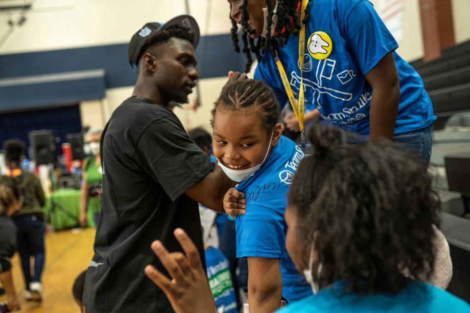 Brenda Scott Academy student Melody Johnson, center, shows off her autographed t-shirt, signed by Detroit Lions Safety Kerby Joseph, during an event at Brenda Scott Academy in Detroit on Friday, June 10, 2022.  Detroit District Dental Society joined the Detroit Lions and Team Smile as volunteer dentists and dental staff to provide free dental care to students.