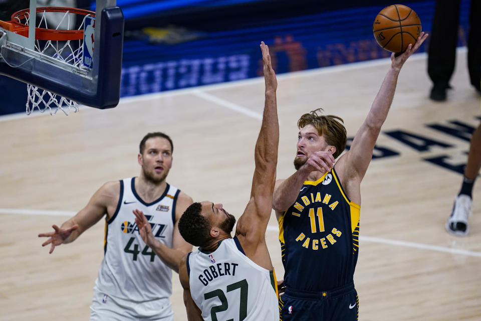 Indiana Pacers forward Domantas Sabonis (11) shoots over Utah Jazz center Rudy Gobert (27) during the second half of an NBA basketball game in Indianapolis, Sunday, Feb. 7, 2021. (AP Photo/Michael Conroy)