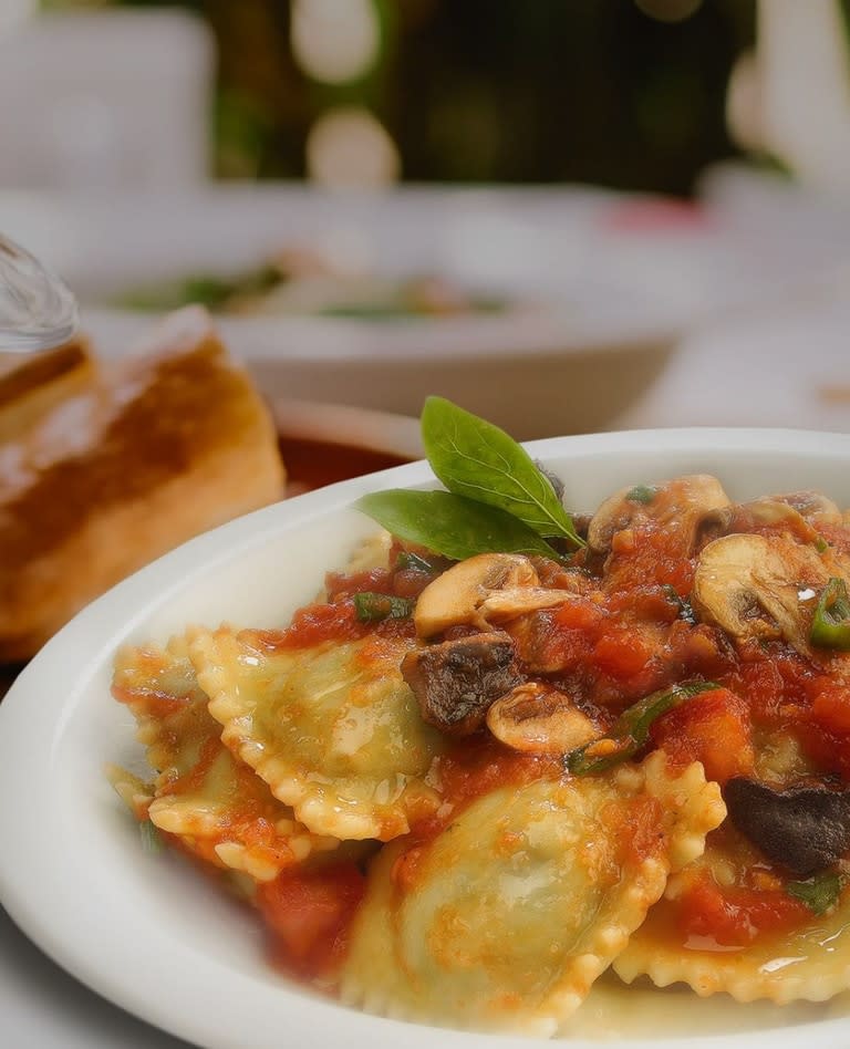 Los ravioles Del Bosco están rellenos de espinaca y ricota y sarteneados con salsa pomodoro, hongos secos, champignones y cebolla de verdeo.