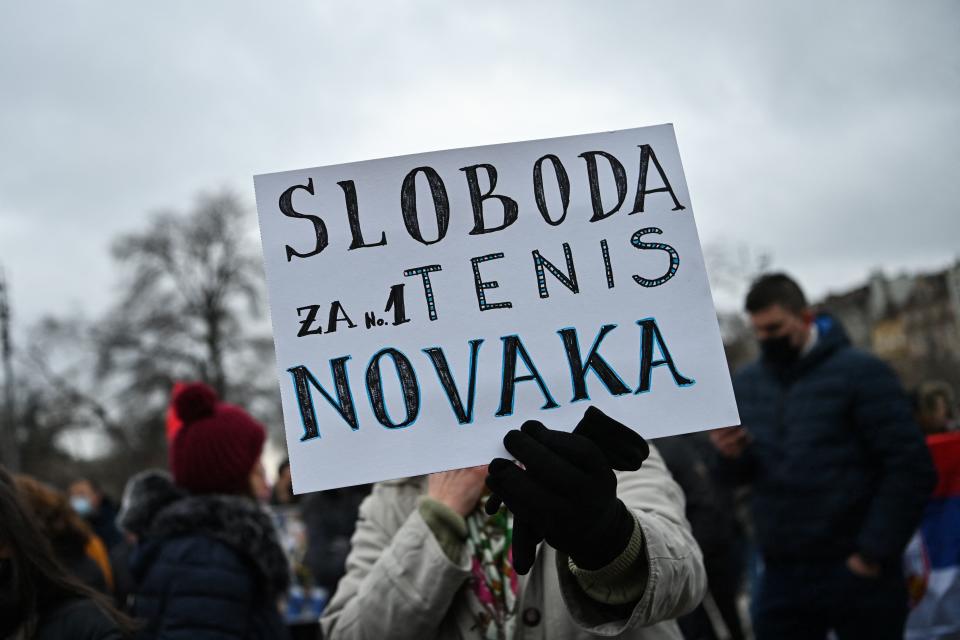 A demonstrator holds a placard reading 