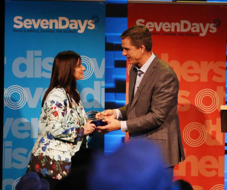 Lisa Ginter, CEO of CommunityAmerica Credit Union, receives the Ripple of Kindness award from Trent Green at the SevenDays kindness breakfast at Church of the Resurrection April 5.