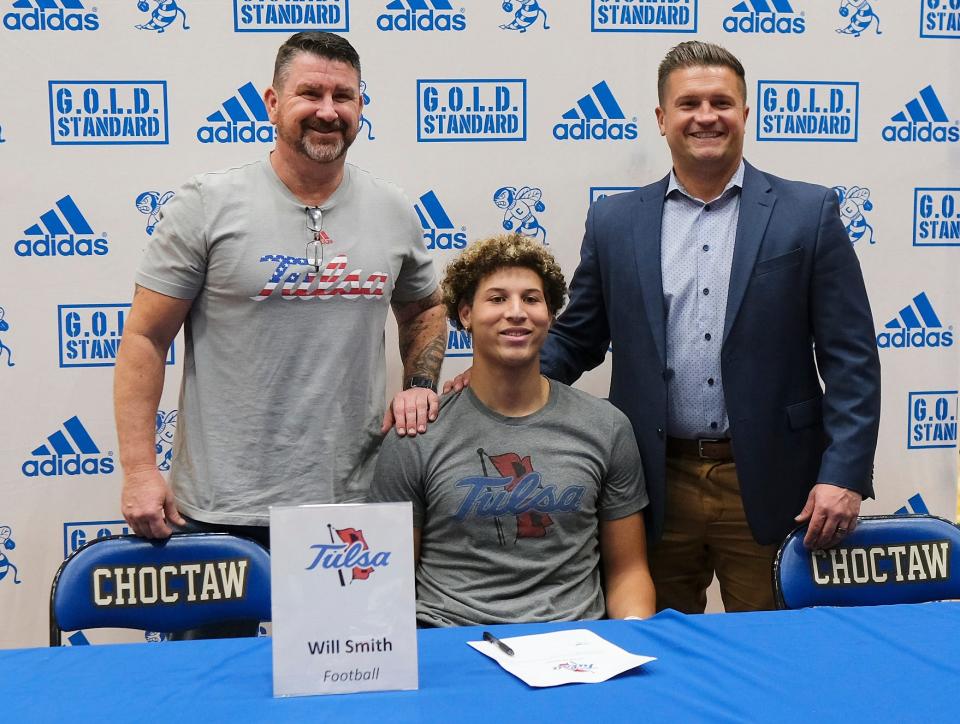 Steve Tarbell, father, and Jake Corbin, head coach, pose with Choctaw outside linebacker Will Smith, who signed with the University of Tulsa, Wednesday, Dec. 20, 2023.