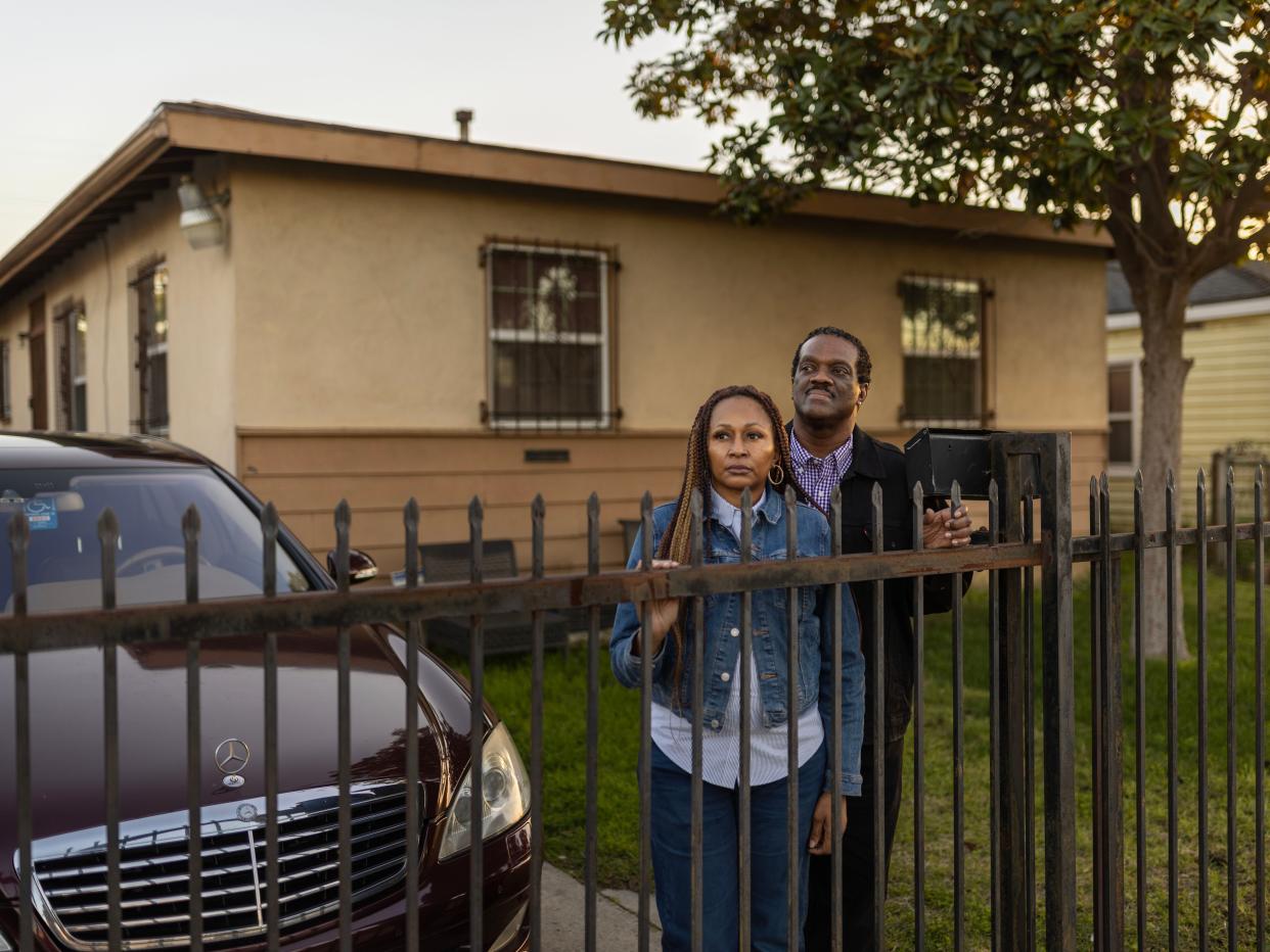 Linda Martin and her husband Reggie are standing at their home's frontgate.