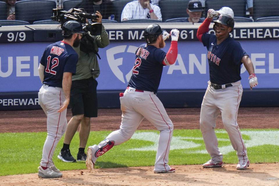 Boston Red Sox's Justin Turner (2) celebrates with Rafael Devers (11) and Connor Wong (12) after hitting a three-run home run during the seventh inning of a baseball game against the New York Yankees, Sunday, Aug. 20, 2023, in New York. (AP Photo/Frank Franklin II)