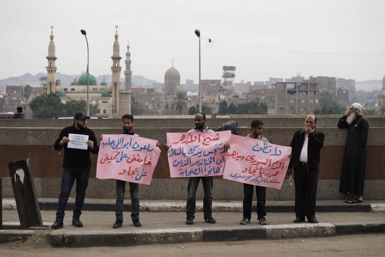 Protesters hold banners against Iranian President Mahmoud Ahmadinejad in Cairo, on February 5, 2013. The men were protesting against Iran over its support for Syrian President Bashar al-Assad's regime in its 22-month conflict with Sunni-led rebels